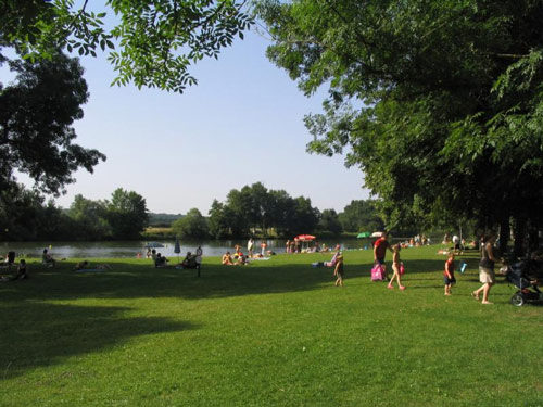 Plage enherbée le long de la Saône et avec des gens et des parasols